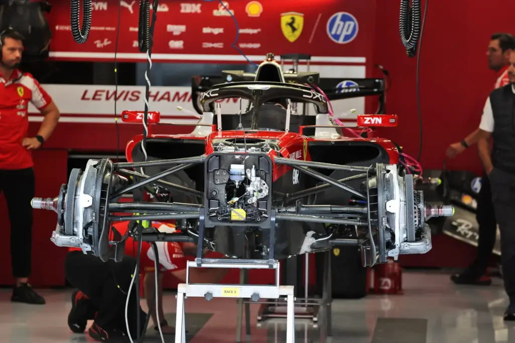 Scuderia Ferrari SF-26 being prepared by mechanics in the pit garage.
