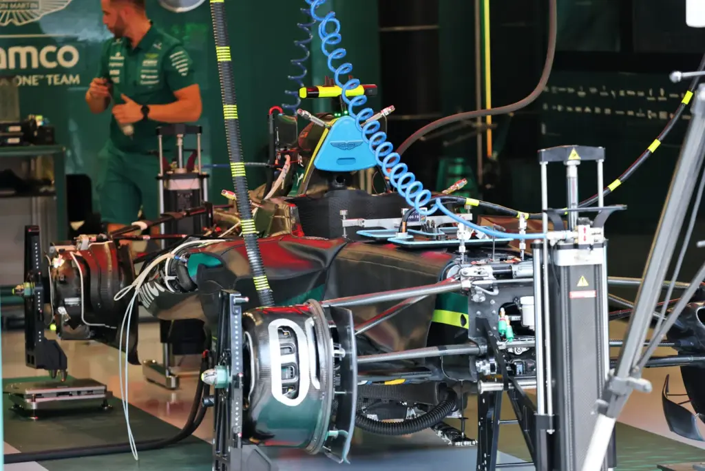 Aston Martin F1 Team AMR26 being prepared by mechanics in the pit garage.