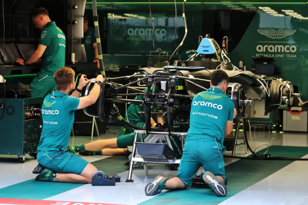 Aston Martin F1 Team being prepared by mechanics in the pit garage.